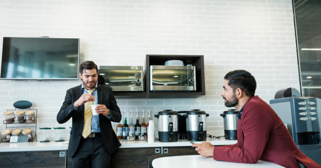 Employees talking in lunch room at workplace.